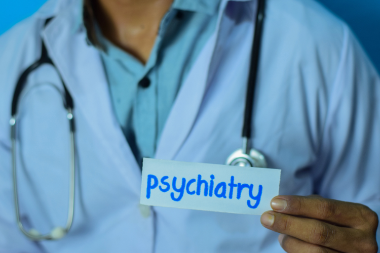 Nurse Practitioner Holding a Note Reading "Psychiatry"